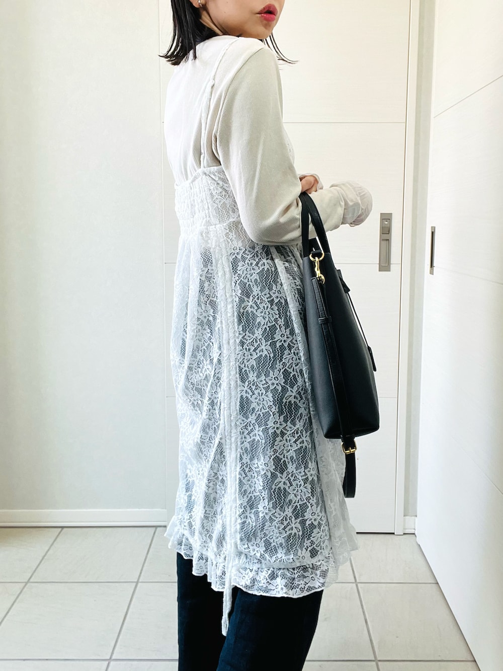 ホワイト系のチュニック、ホワイト系のTシャツ/カットソー、ブルー系のデニムパンツを着用したレディースの春コーディネートの4枚目の写真