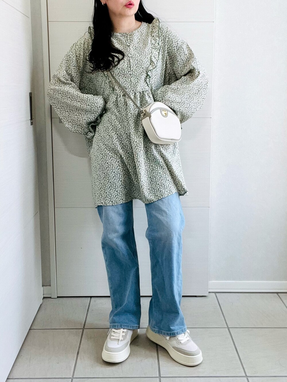 グリーン系のシャツ/ブラウス、ブルー系のデニムパンツ、ホワイト系のスニーカーを着用したレディースの春コーディネートの2枚目の写真