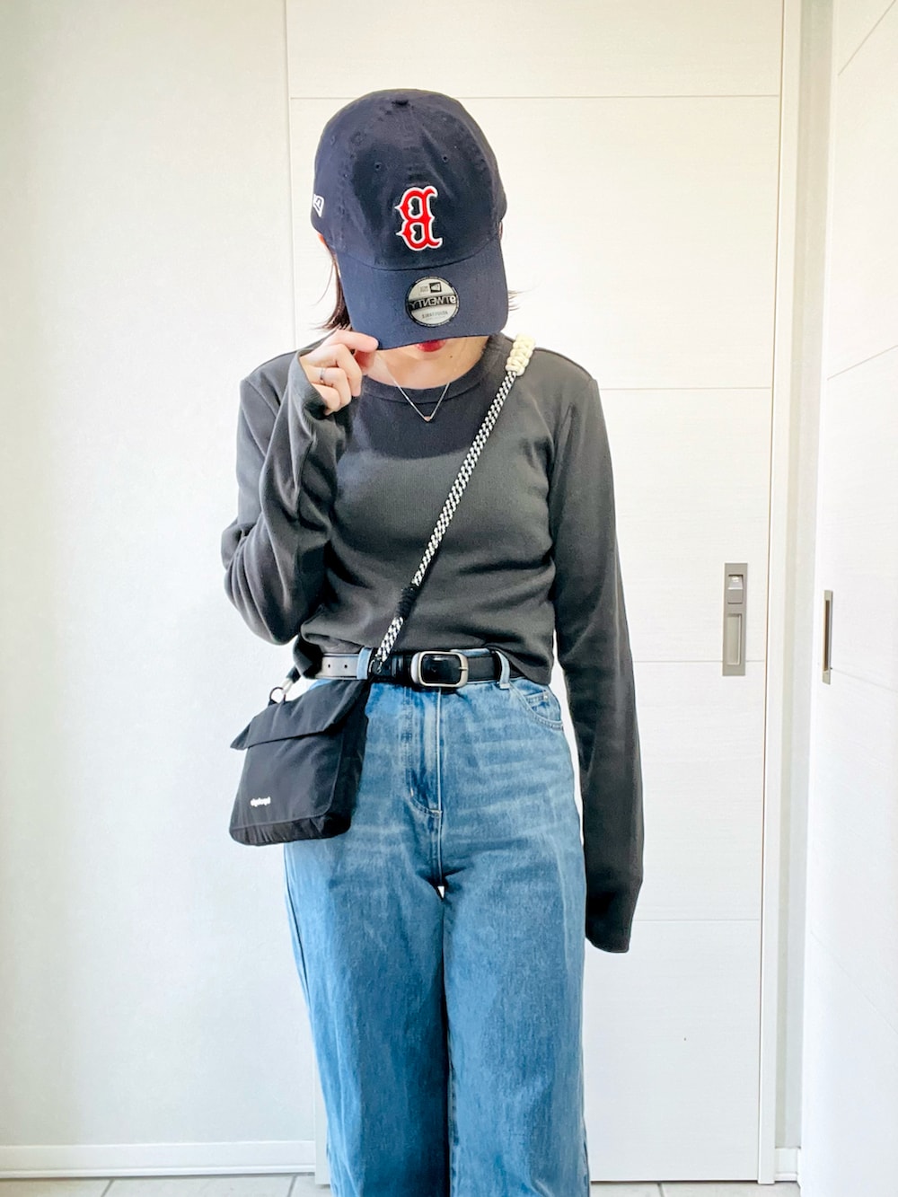 グレー系のスニーカー、グレー系のTシャツ/カットソー、ブラック系のショルダーバッグを着用したレディースの夏コーディネートの2枚目の写真