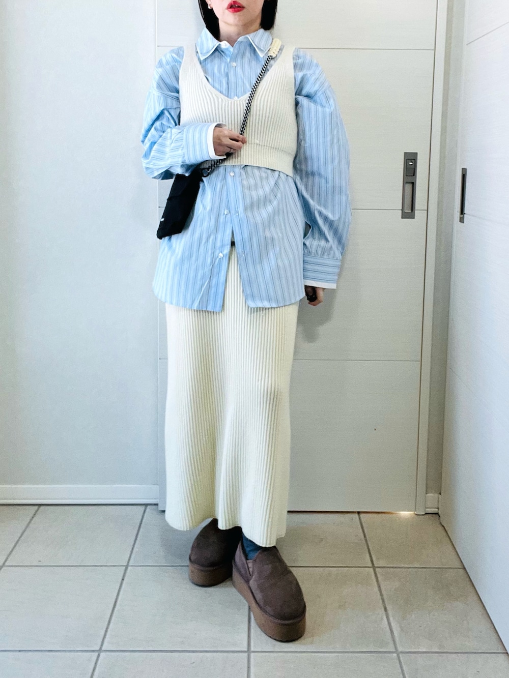 ブルー系のシャツ/ブラウス、ホワイト系のスカート、ブラック系のショルダーバッグを着用したレディースの冬コーディネートの4枚目の写真