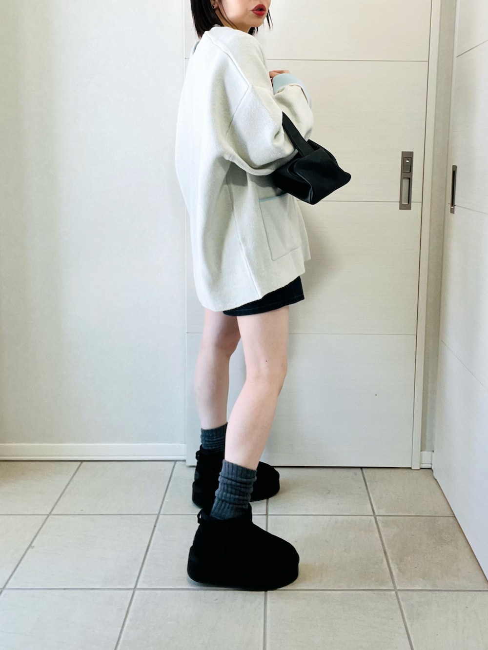 ホワイト系のカーディガン/ボレロ、ブラック系のブーツ、ブラック系のその他パンツを着用したレディースの冬コーディネートの4枚目の写真