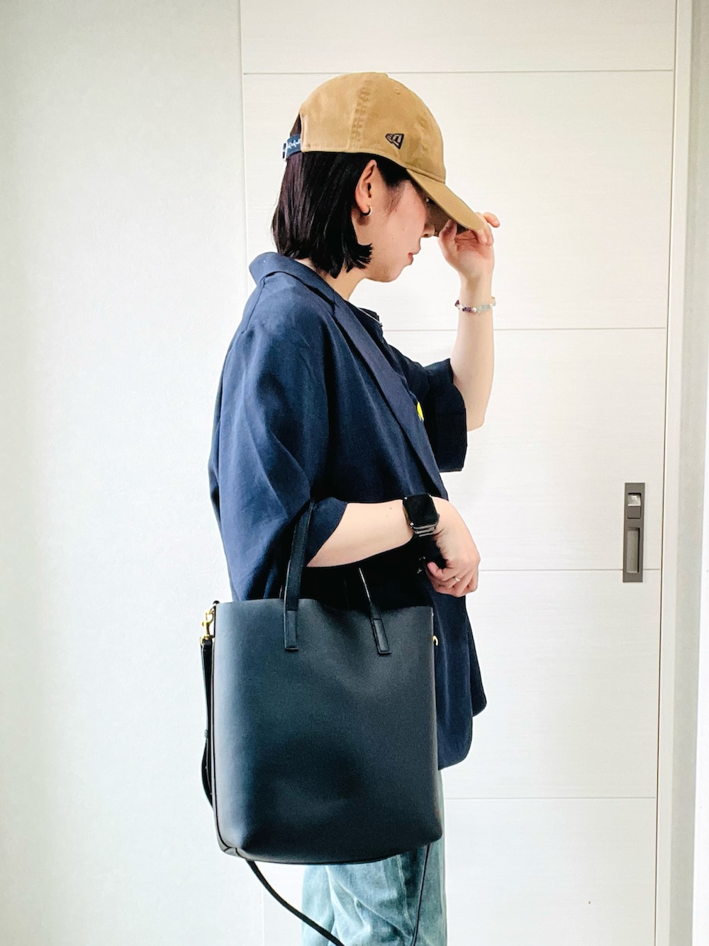 ブルー系のテーラードジャケット、グレー系のスニーカー、ブルー系のデニムパンツを着用したレディースの夏コーディネートの5枚目の写真