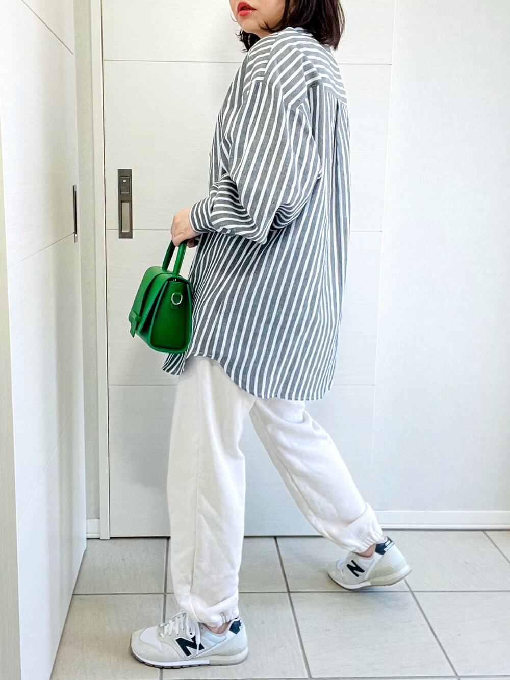 ブラック系のシャツ/ブラウス、ホワイト系のスウェットパンツ、ホワイト系のスニーカーを着用したレディースの春コーディネートの4枚目の写真