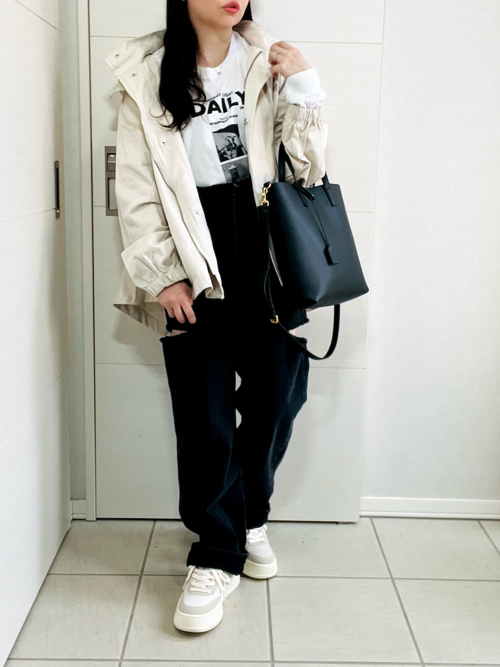 ホワイト系のマウンテンパーカー、ホワイト系のTシャツ/カットソー、ブラック系のデニムパンツを着用したレディースの春コーディネートの4枚目の写真