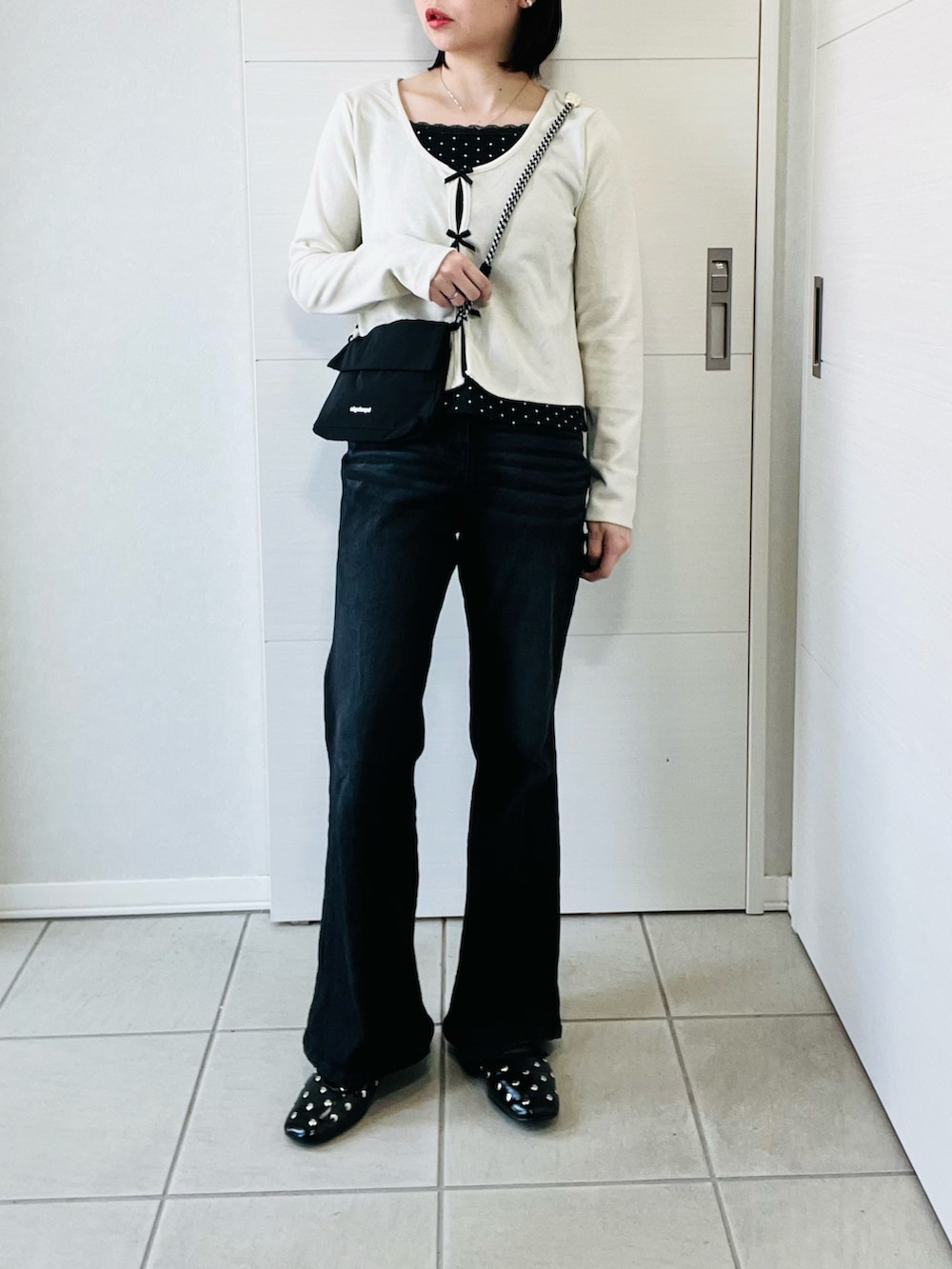 ホワイト系のTシャツ/カットソー、ブラック系のデニムパンツ、ブラック系のショルダーバッグを着用したレディースの春コーディネートの4枚目の写真