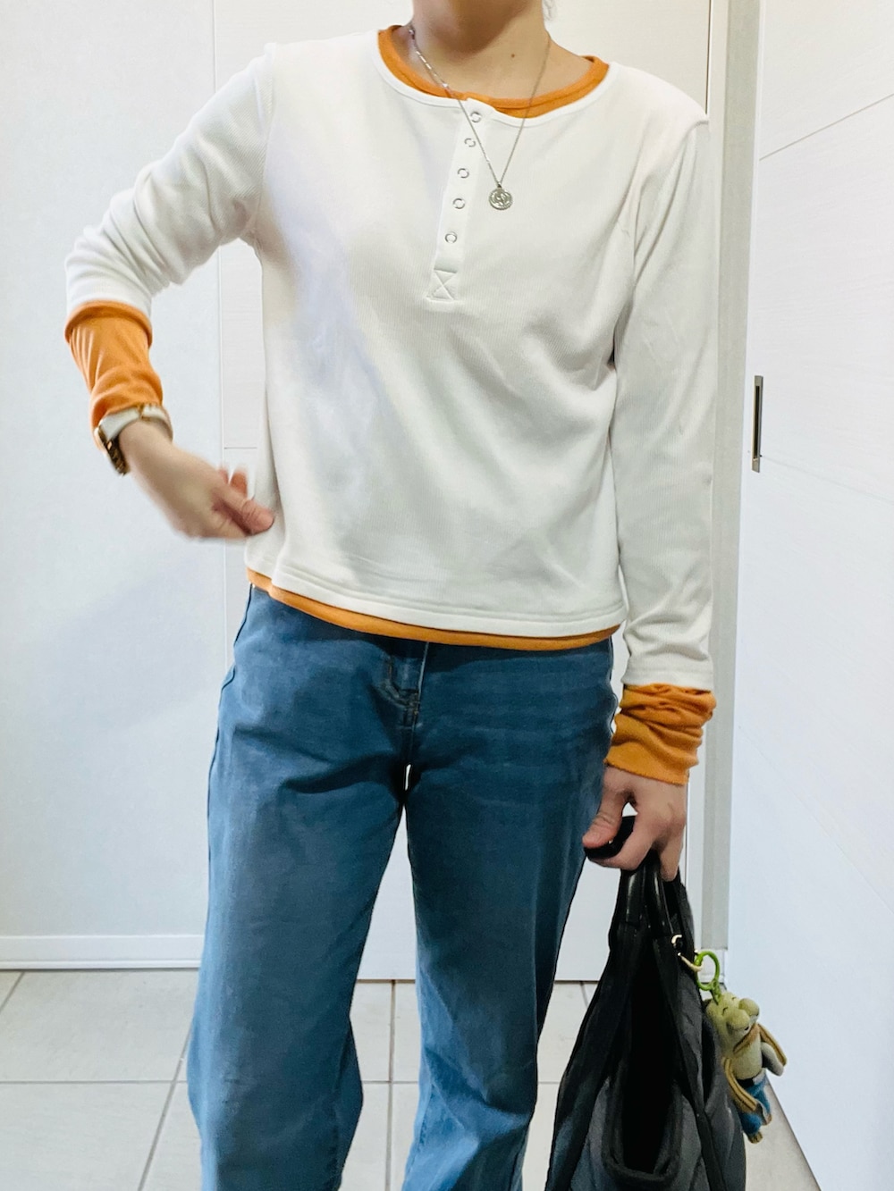 ブルー系のデニムパンツ、ホワイト系のTシャツ/カットソー、ブラック系のスニーカーを着用したレディースの春コーディネートの2枚目の写真