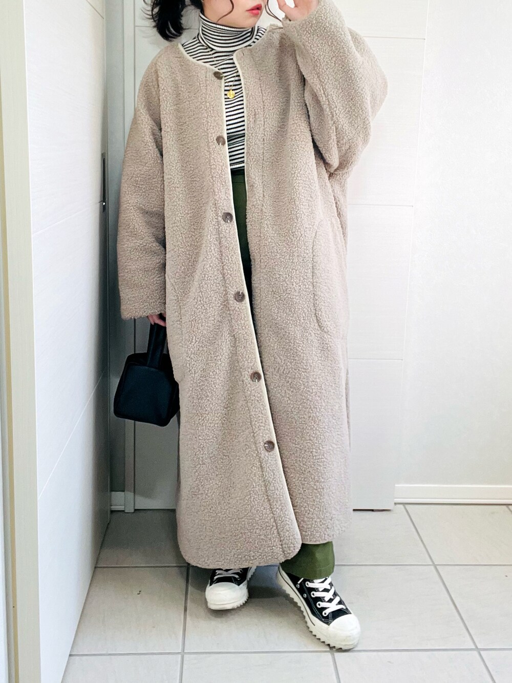 ホワイト系のその他アウター、その他のニット/セーター、ブラック系のスニーカーを着用したレディースの秋コーディネートの2枚目の写真