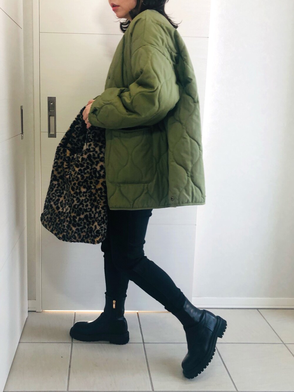 グレー系のスウェット、グリーン系のブルゾン、ブラック系のデニムパンツを着用したレディースの冬コーディネートの4枚目の写真