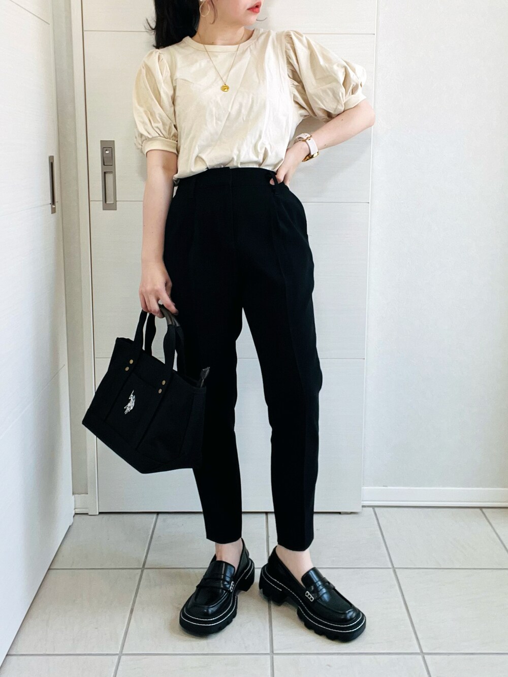 ベージュ系のTシャツ/カットソー、ブラック系のパンツ、ブラック系のローファーを着用したレディースの春コーディネートの3枚目の写真