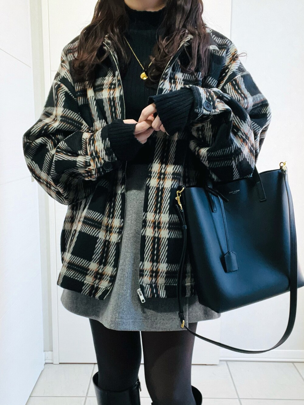 ブラック系のブルゾン、ブラック系のニット/セーター、グレー系のその他パンツを着用したレディースの冬コーディネートの3枚目の写真