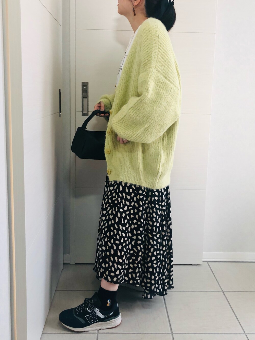 グリーン系のカーディガン/ボレロ、ホワイト系のTシャツ/カットソー、ブラック系のスニーカーを着用したレディースの秋コーディネートの2枚目の写真