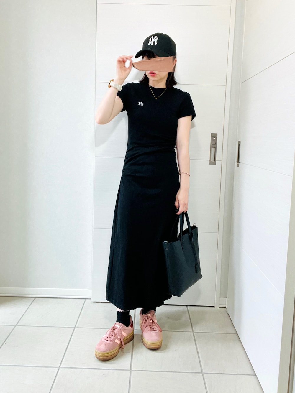 ブラック系のワンピース、レッド系のスニーカー、ブラック系のトートバッグを着用したレディースの夏コーディネートの5枚目の写真