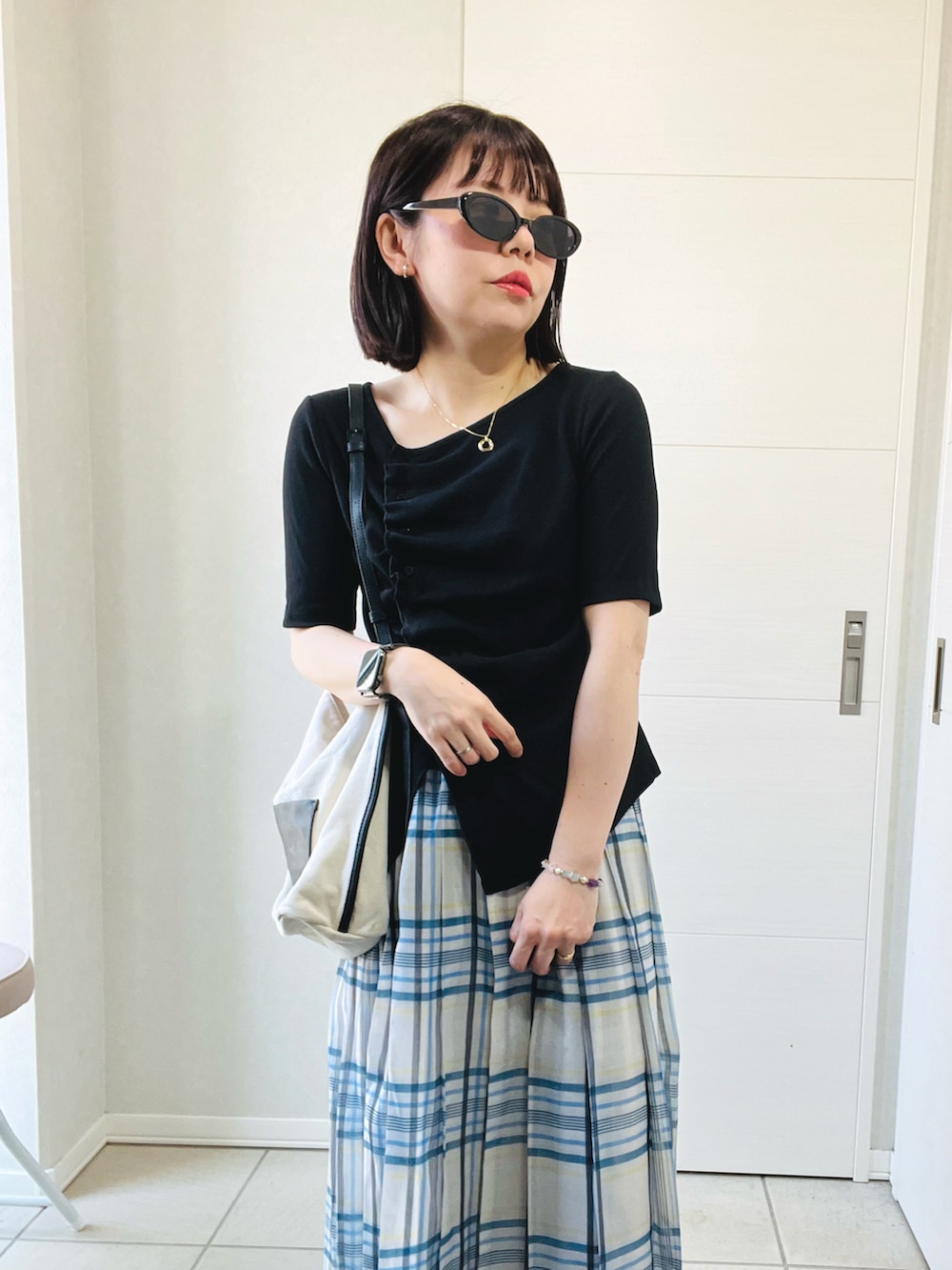 ブラック系のTシャツ/カットソー、ホワイト系のスカート、ブラック系のスニーカーを着用したレディースの秋コーディネートの3枚目の写真