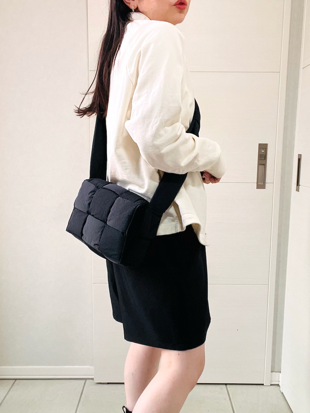 ホワイト系のスウェット、ブラック系のその他パンツ、ブラック系のブーツを着用したレディースの秋コーディネートの3枚目の写真