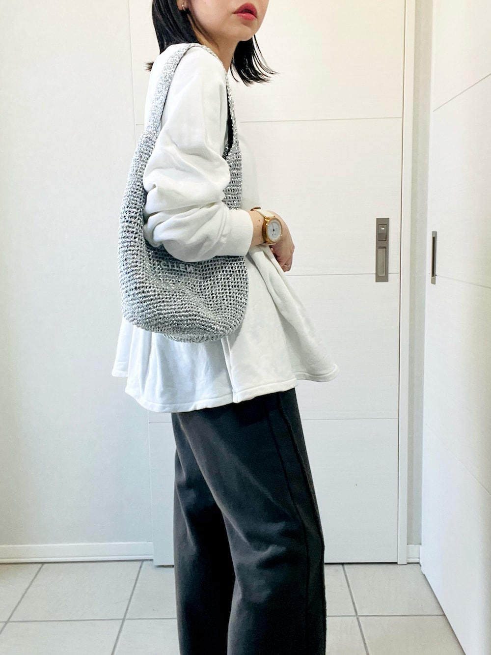 ホワイト系のスウェット、ブラック系のスウェットパンツ、レッド系のスニーカーを着用したレディースの春コーディネートの3枚目の写真