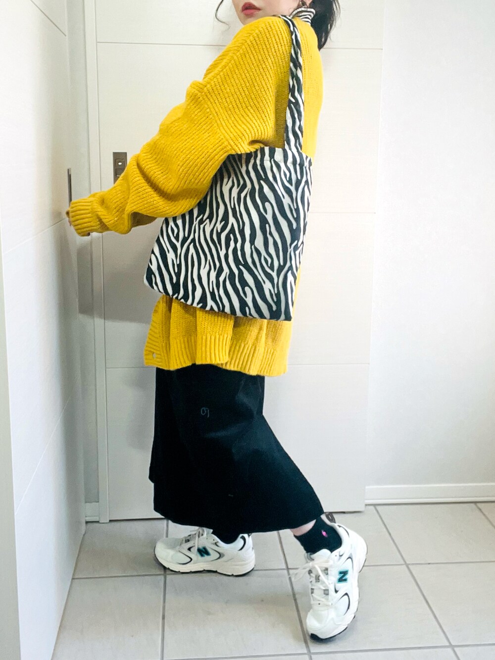 イエロー系のカーディガン/ボレロ、その他のニット/セーター、ブラック系のジャンパースカートを着用したレディースの冬コーディネートの5枚目の写真