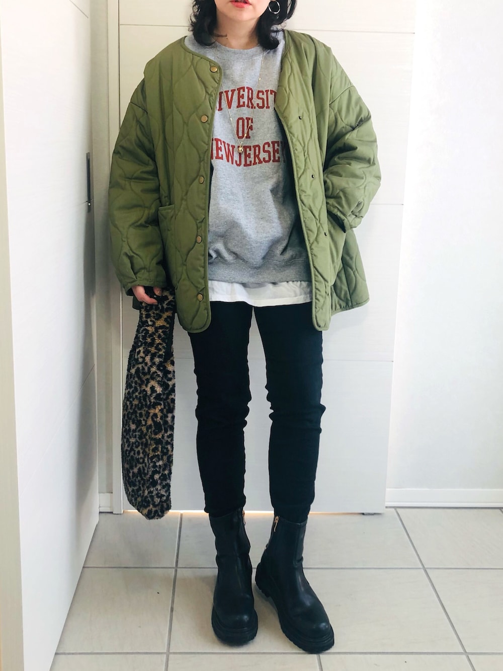 グレー系のスウェット、グリーン系のブルゾン、ブラック系のデニムパンツを着用したレディースの冬コーディネートの3枚目の写真