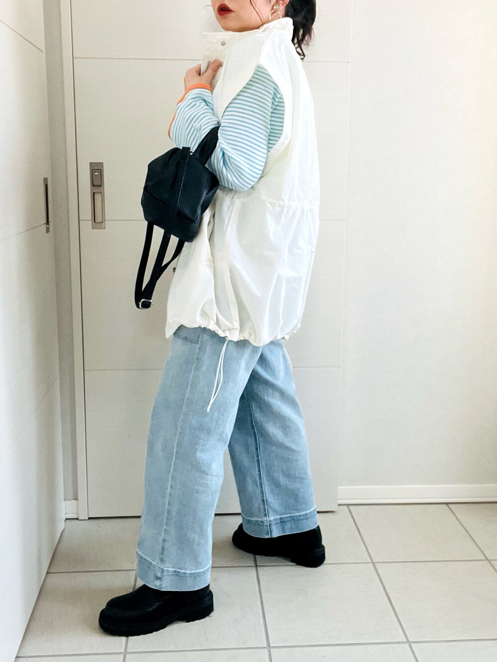 ホワイト系のブルゾン、ブルー系のTシャツ/カットソー、ブルー系のデニムパンツを着用したレディースの冬コーディネートの5枚目の写真