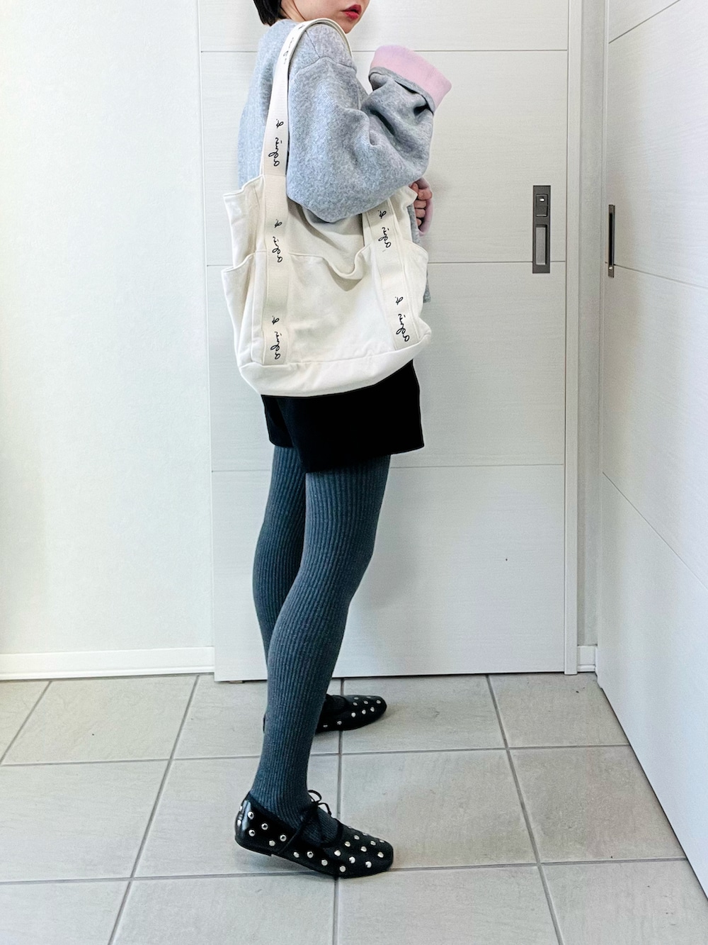 グレー系のカーディガン/ボレロ、ブラック系のバレエシューズ、ベージュ系のトートバッグを着用したレディースの秋コーディネートの5枚目の写真
