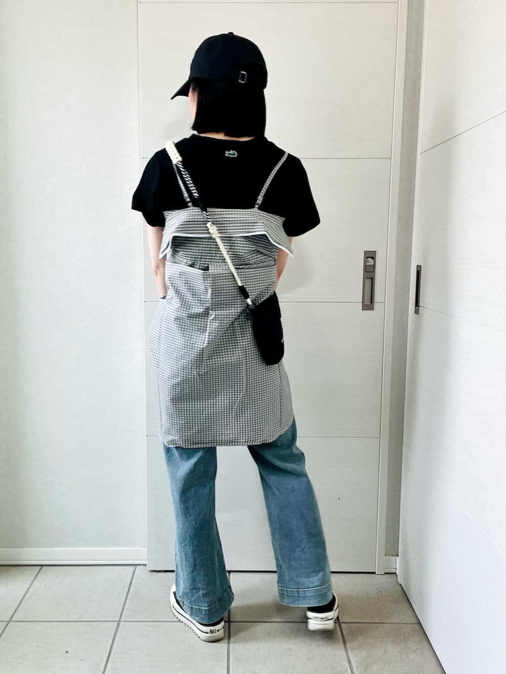 ホワイト系のシャツ/ブラウス、ブラック系のスニーカー、ブルー系のデニムパンツを着用したレディースの夏コーディネートの5枚目の写真