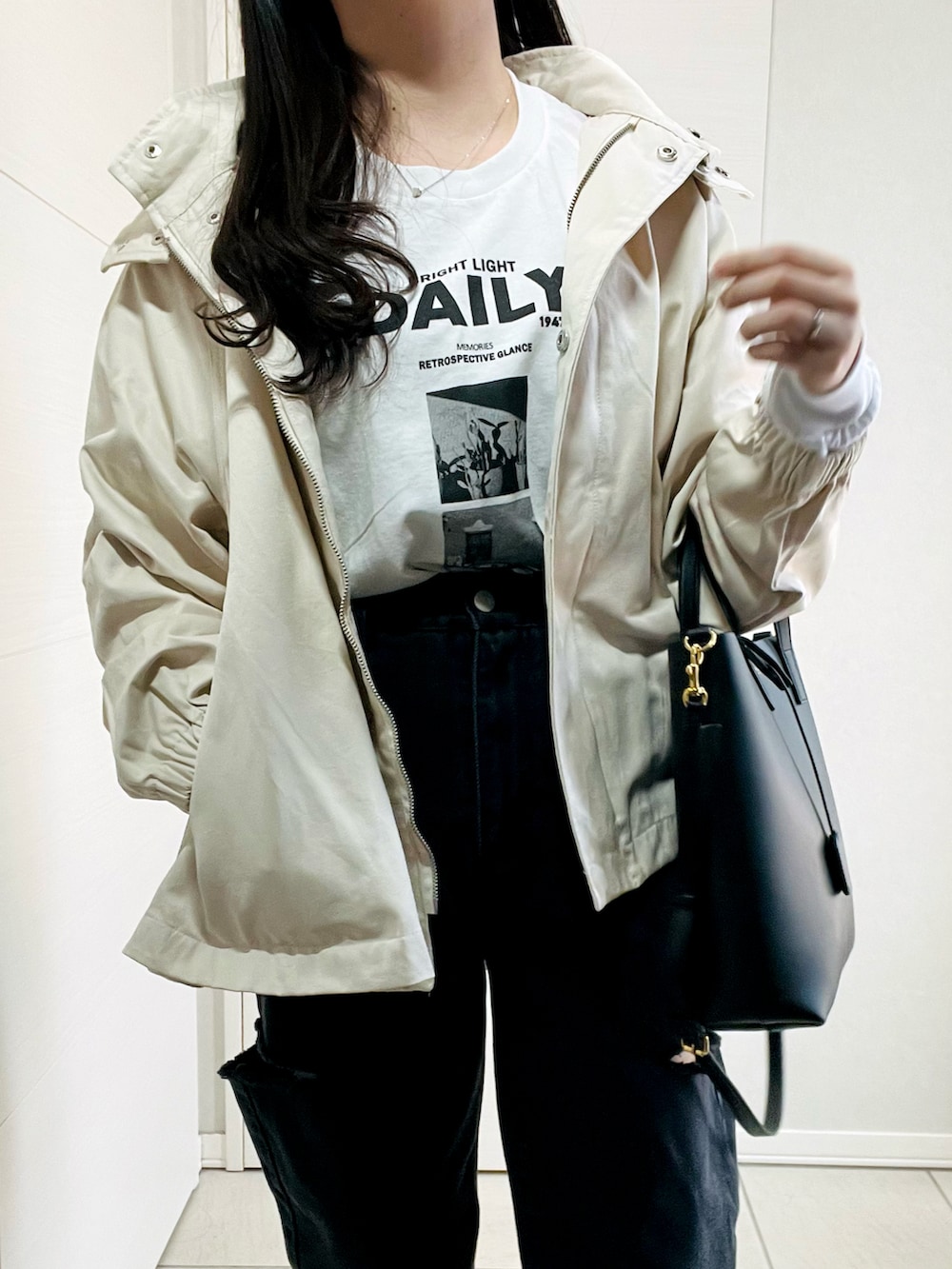 ホワイト系のマウンテンパーカー、ホワイト系のTシャツ/カットソー、ブラック系のデニムパンツを着用したレディースの春コーディネートの2枚目の写真