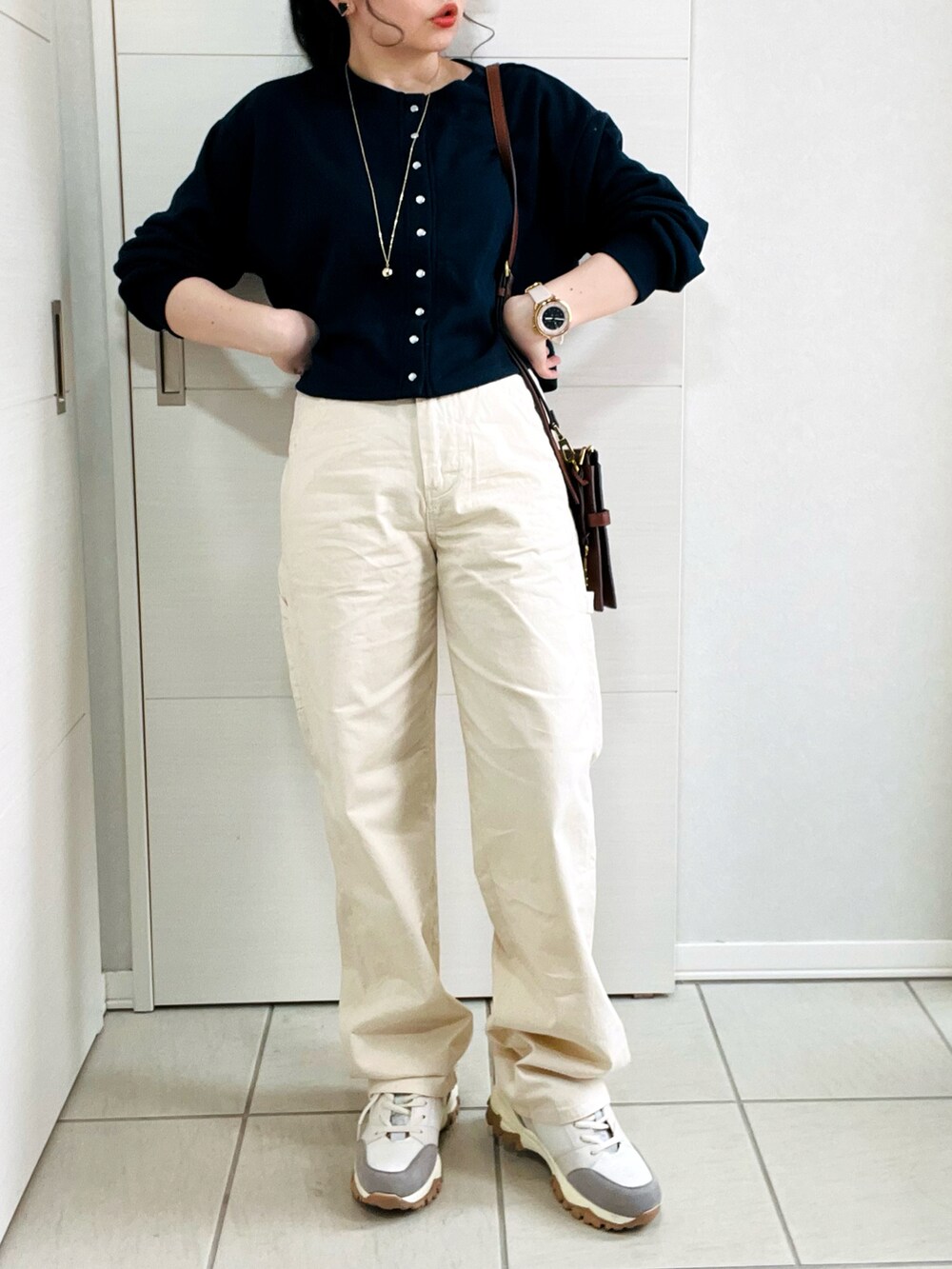 ホワイト系のデニムパンツ、ブルー系のカーディガン/ボレロ、ベージュ系のスニーカーを着用したレディースの春コーディネートの4枚目の写真