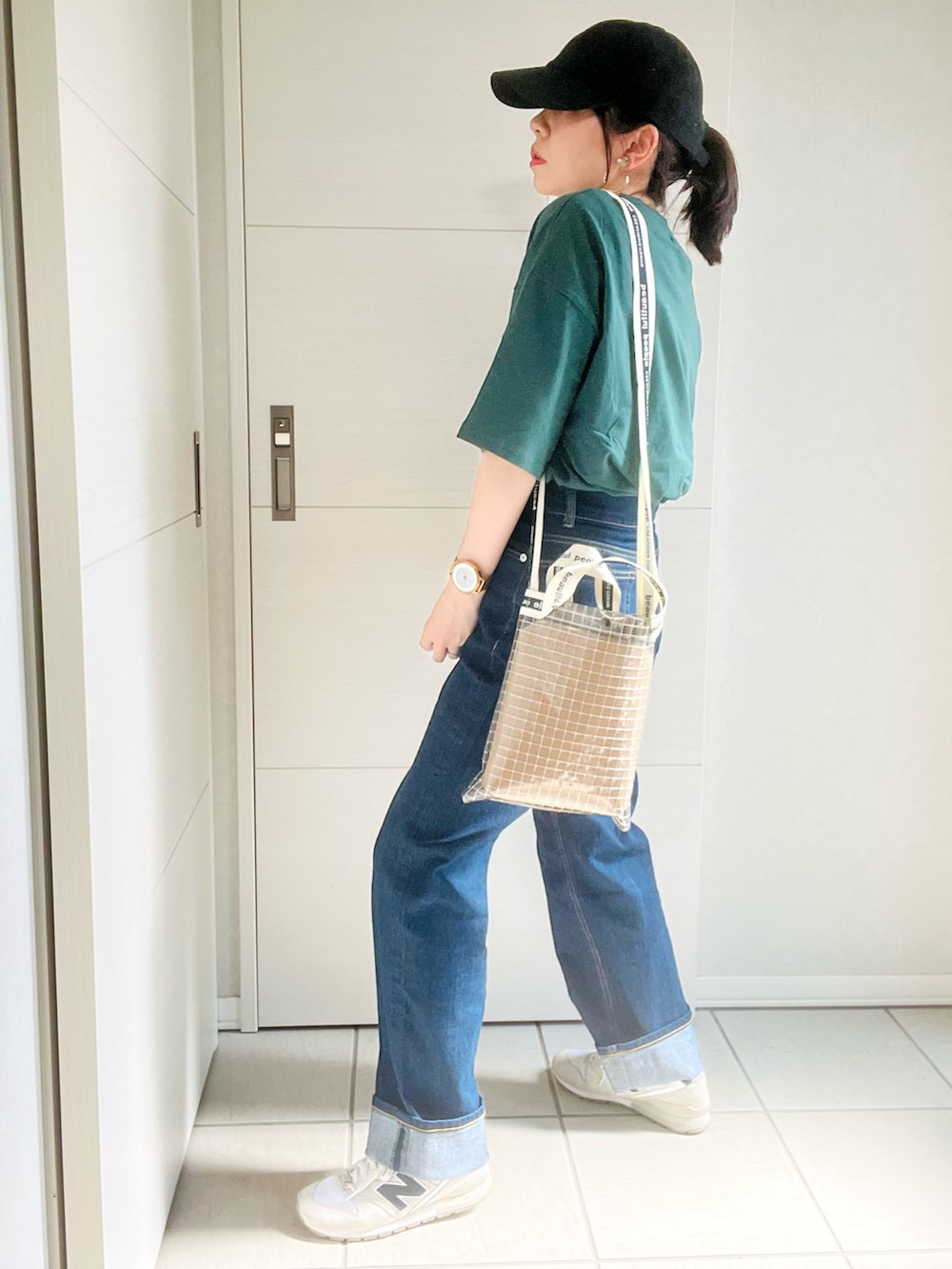 グリーン系のTシャツ/カットソー、ブルー系のデニムパンツ、ホワイト系のスニーカーを着用したレディースの夏コーディネートの4枚目の写真