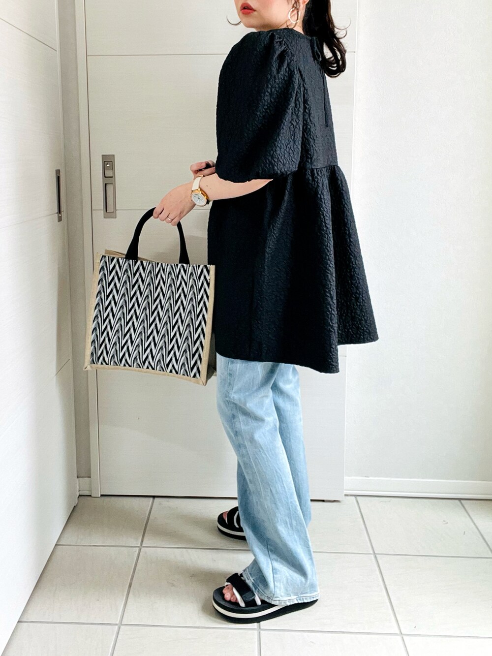 ブラック系のシャツ/ブラウス、ブルー系のデニムパンツ、ブラック系のサンダルを着用したレディースの夏コーディネートの4枚目の写真