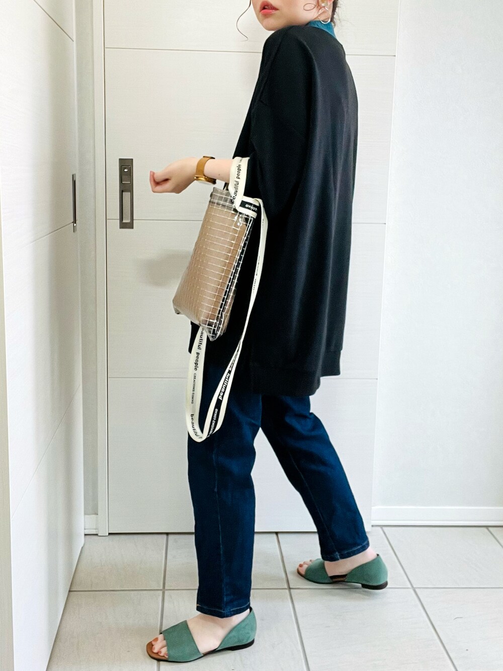 ブラック系のTシャツ/カットソー、ブルー系のデニムパンツ、グリーン系のサンダルを着用したレディースの夏コーディネートの5枚目の写真