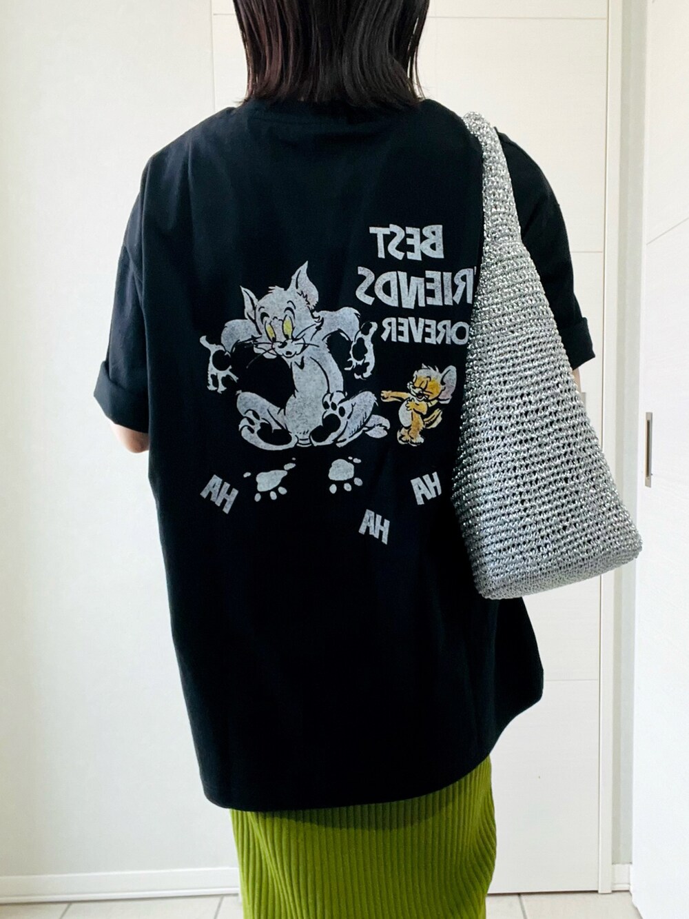 ブラック系のTシャツ/カットソー、グリーン系のスカート、ブラック系のローファーを着用したレディースの春コーディネートの2枚目の写真
