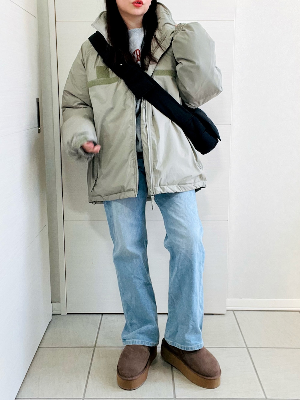グリーン系のダウンジャケット/コート、ブルー系のデニムパンツ、ベージュ系のスリッポンを着用したレディースの冬コーディネートの4枚目の写真