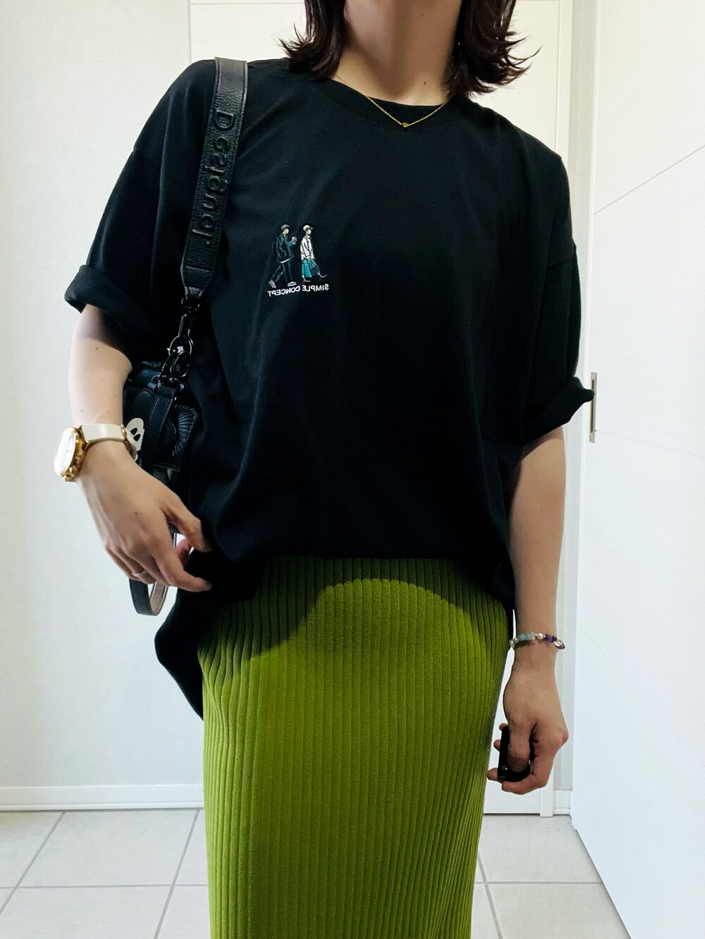 ブラック系のハンドバッグ、ブラック系のスニーカー、ブラック系のTシャツ/カットソーを着用したレディースの夏コーディネートの2枚目の写真