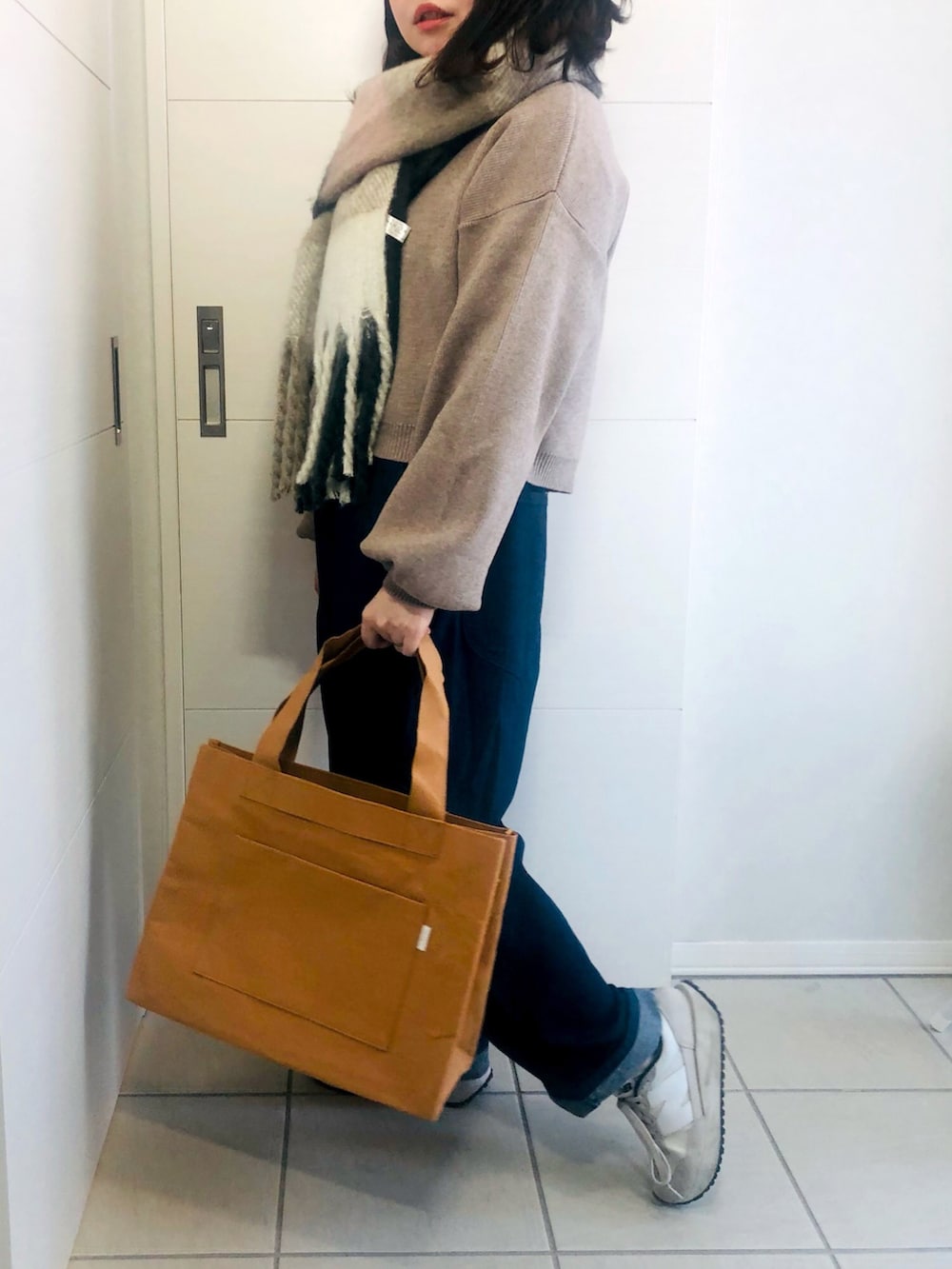 ベージュ系のカーディガン/ボレロ、ブルー系のその他パンツ、ホワイト系のスニーカーを着用したレディースの冬コーディネートの3枚目の写真