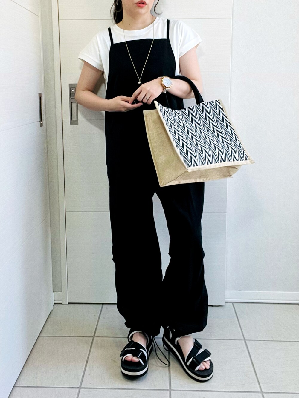 ホワイト系のTシャツ/カットソー、ブラック系のサロペット/オーバーオール、ブラック系のかごバッグを着用したレディースの夏コーディネートの2枚目の写真