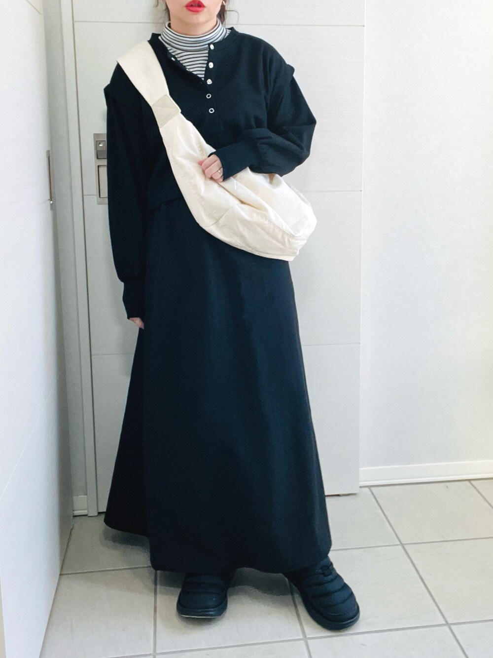 ブラック系のワンピース、ホワイト系のショルダーバッグ、グリーン系のノーカラージャケットを着用したレディースの冬コーディネートの3枚目の写真