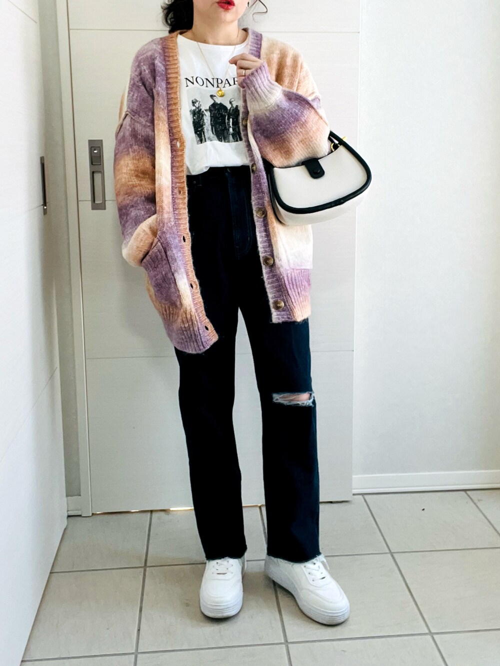 ブラウン系のカーディガン/ボレロ、ホワイト系のTシャツ/カットソー、ブルー系のデニムパンツを着用したレディースの冬コーディネートの3枚目の写真