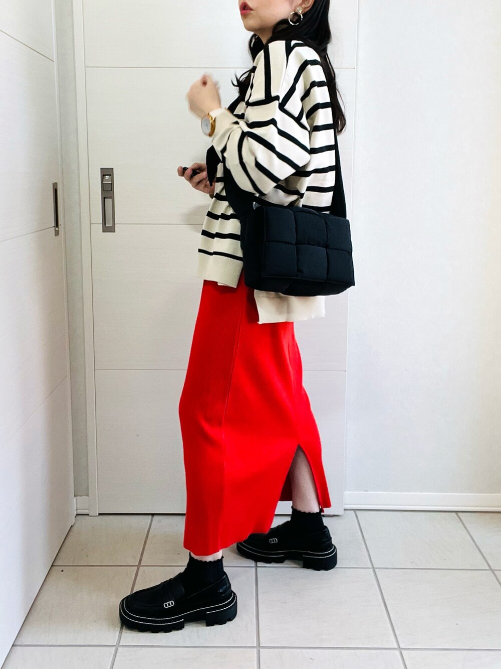 ホワイト系のニット/セーター、オレンジ系のスカート、ブラック系のローファーを着用したレディースの秋コーディネートの5枚目の写真