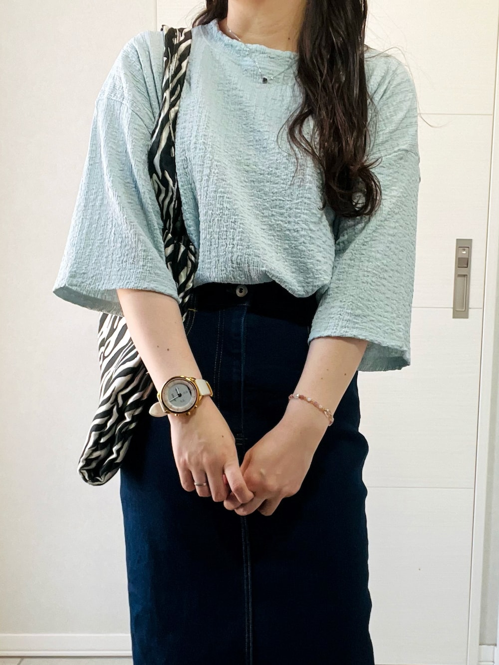 ブルー系のシャツ/ブラウス、ブルー系のデニムスカート、ブラック系のサンダルを着用したレディースの夏コーディネートの2枚目の写真