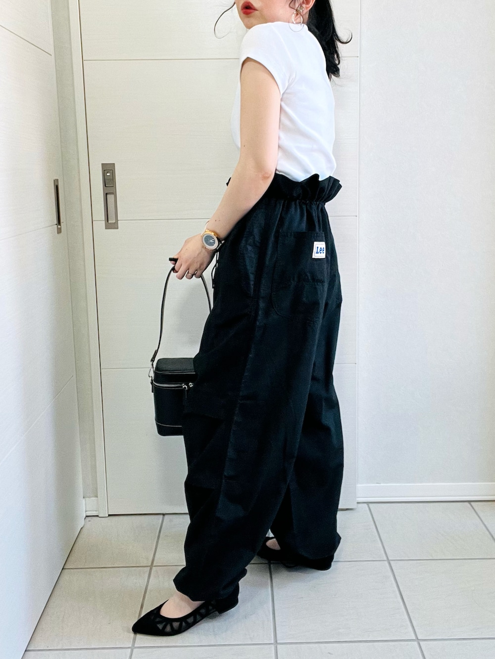 ホワイト系のTシャツ/カットソー、ブラック系のカーゴパンツ、ブラック系のパンプスを着用したレディースの春コーディネートの5枚目の写真