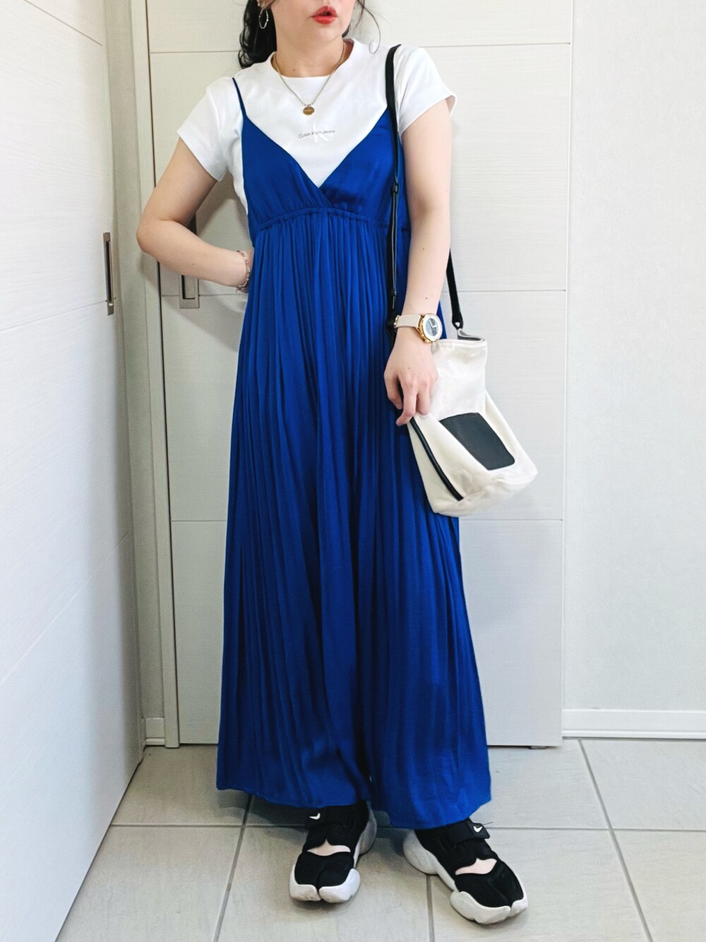 ホワイト系のTシャツ/カットソー、ブルー系のワンピース、ブラック系のスニーカーを着用したレディースの春コーディネートの4枚目の写真
