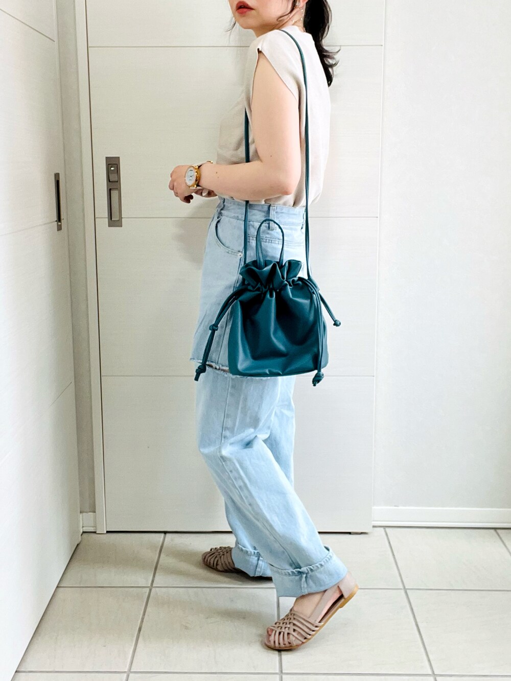 ベージュ系のニット/セーター、ブルー系のデニムパンツ、グレー系のサンダルを着用したレディースの夏コーディネートの3枚目の写真