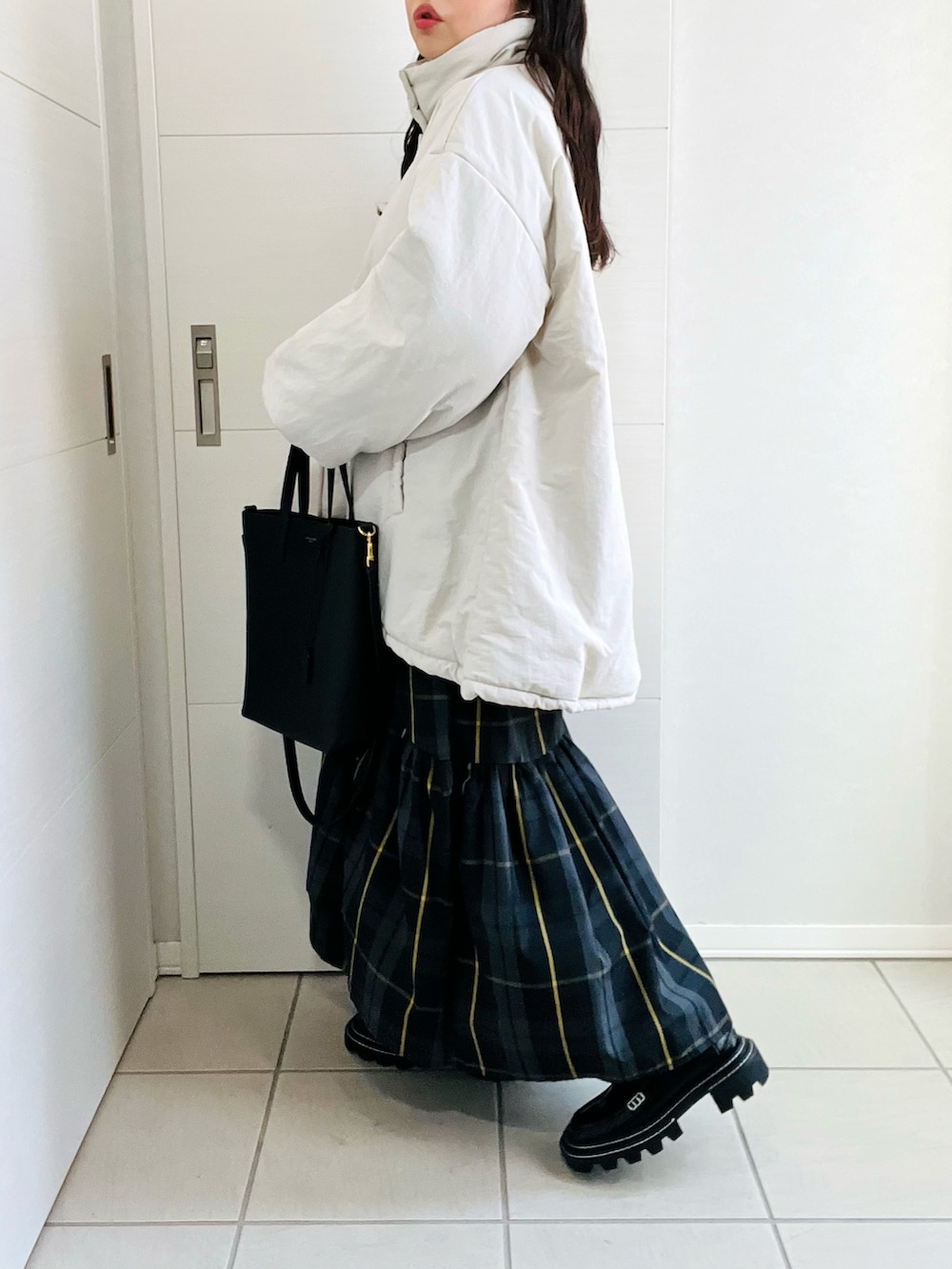 ホワイト系のブルゾン、グレー系のニット/セーター、ブラック系のスカートを着用したレディースの秋コーディネートの2枚目の写真