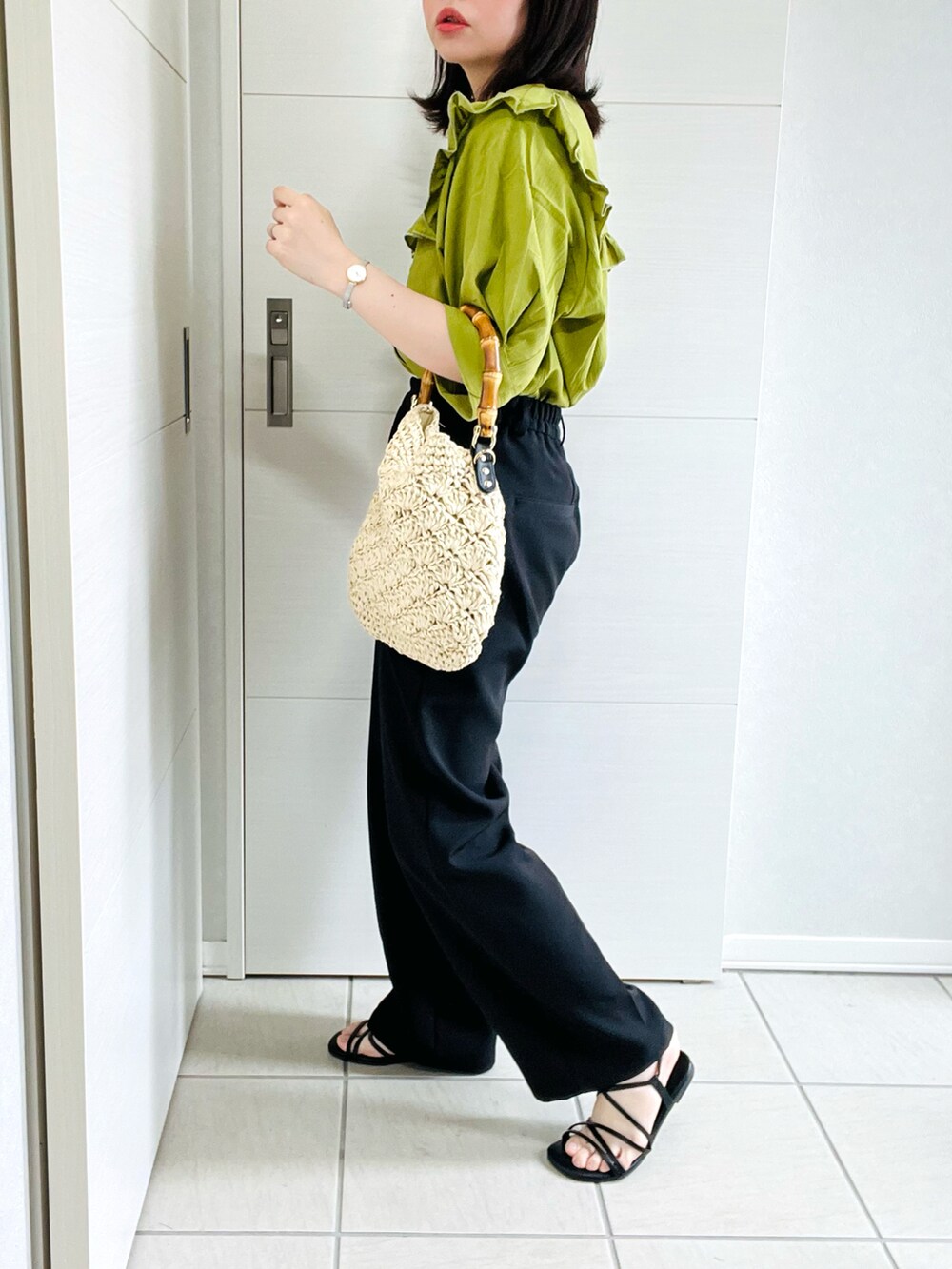グリーン系のシャツ/ブラウス、ブラック系のスラックス、ブラック系のサンダルを着用したレディースの夏コーディネートの4枚目の写真