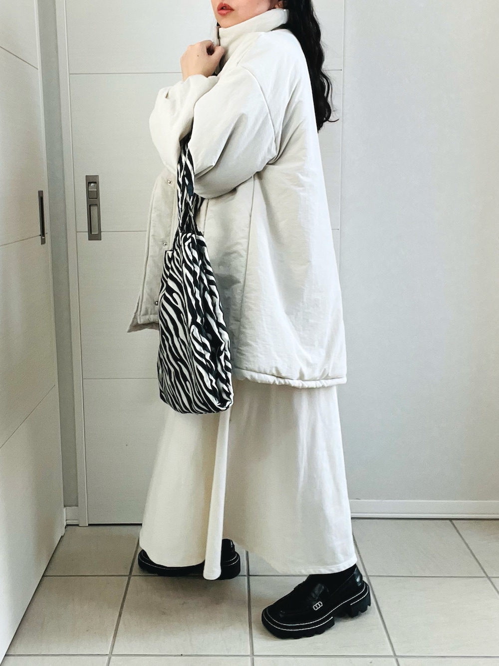 ホワイト系のブルゾン、ホワイト系のワンピース、ブラック系のローファーを着用したレディースの秋コーディネートの5枚目の写真