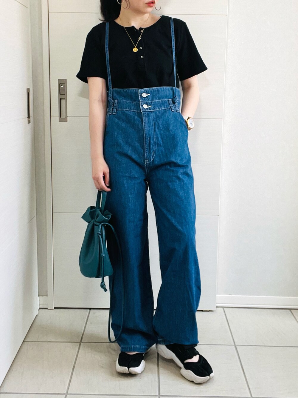 ブルー系のサロペット/オーバーオール、ブラック系のTシャツ/カットソー、ブラック系のスニーカーを着用したレディースの夏コーディネートの2枚目の写真