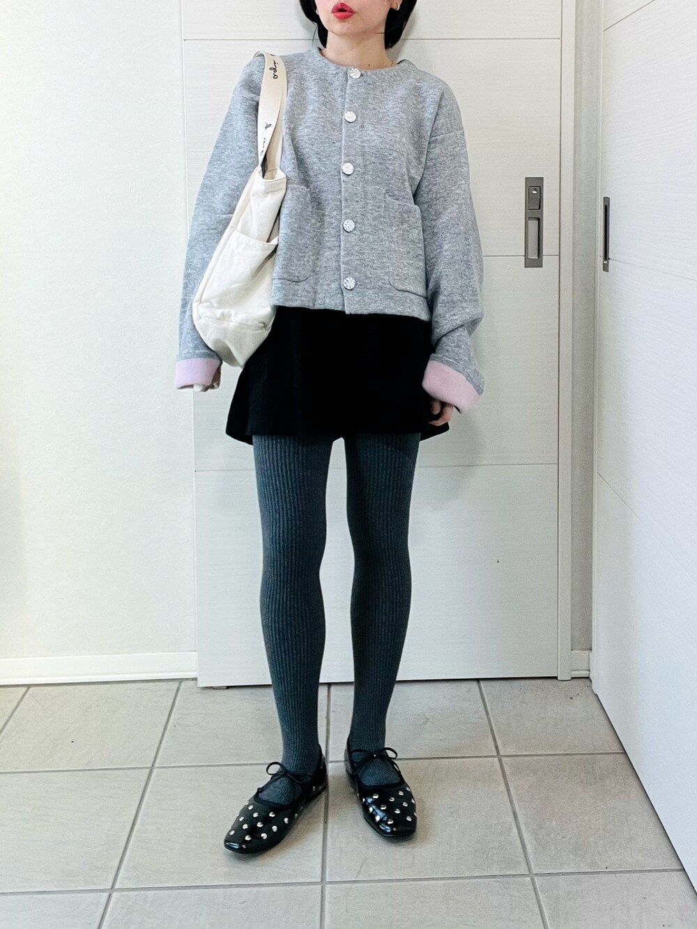 グレー系のカーディガン/ボレロ、ブラック系のバレエシューズ、ベージュ系のトートバッグを着用したレディースの秋コーディネートの4枚目の写真