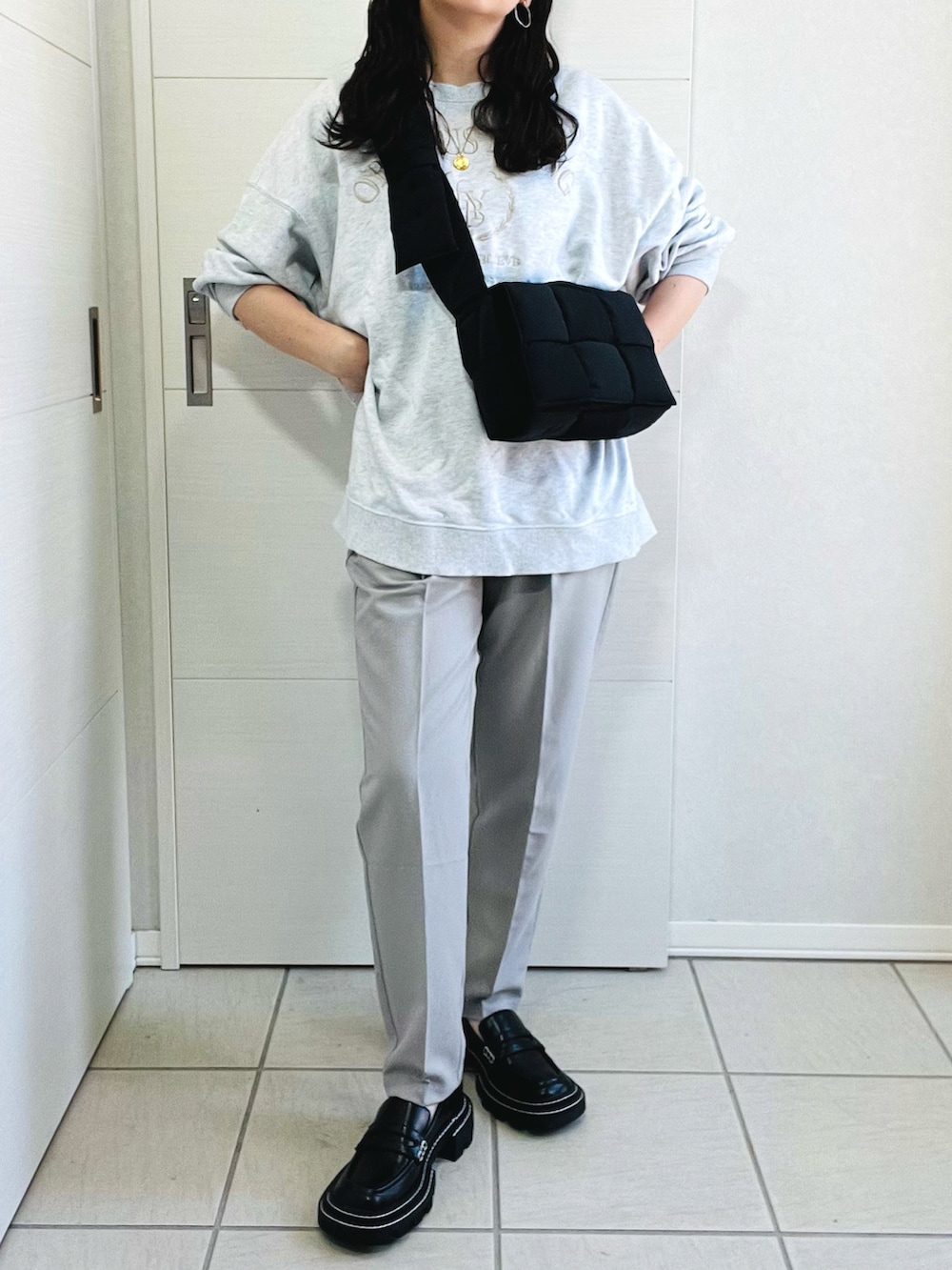 グレー系のスウェット、シルバー系のその他パンツ、ブラック系のローファーを着用したレディースの秋コーディネートの2枚目の写真