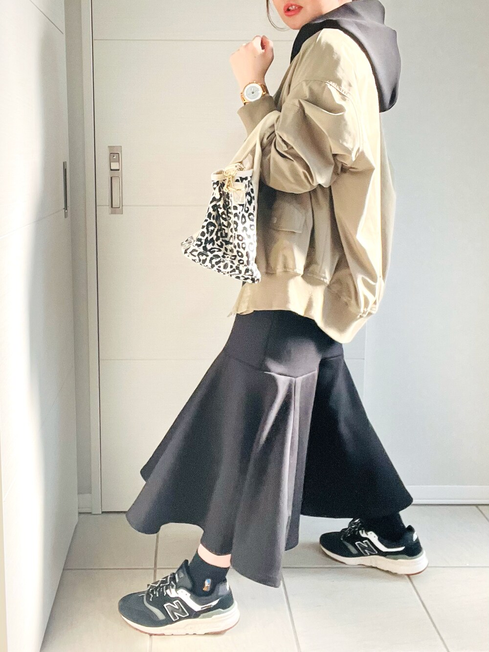 グリーン系のMA-1、ブラック系のワンピース、ブラック系のスニーカーを着用したレディースの春コーディネートの4枚目の写真