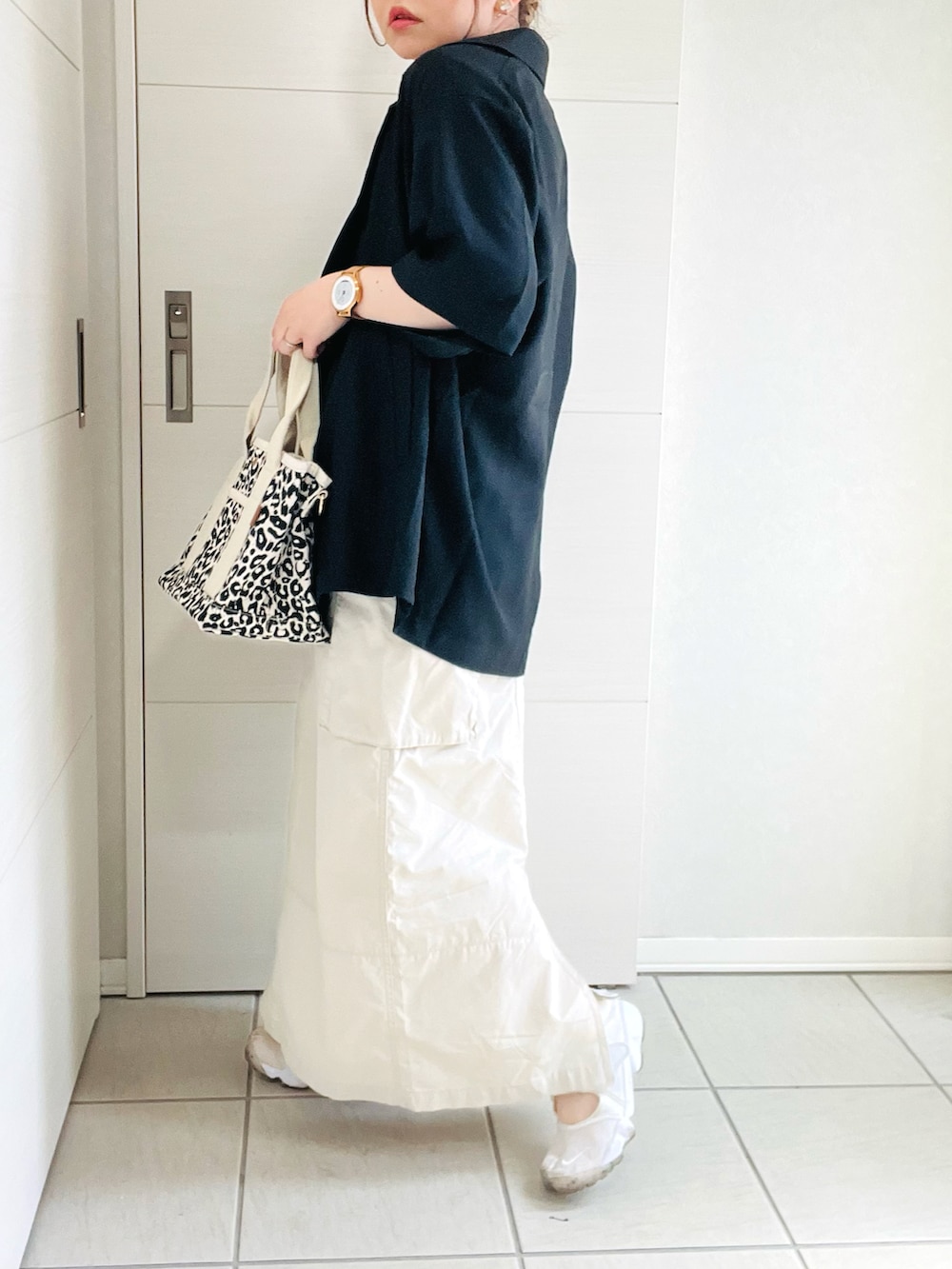 ホワイト系のTシャツ/カットソー、ブラック系のシャツ/ブラウス、ホワイト系のスカートを着用したレディースの春コーディネートの4枚目の写真