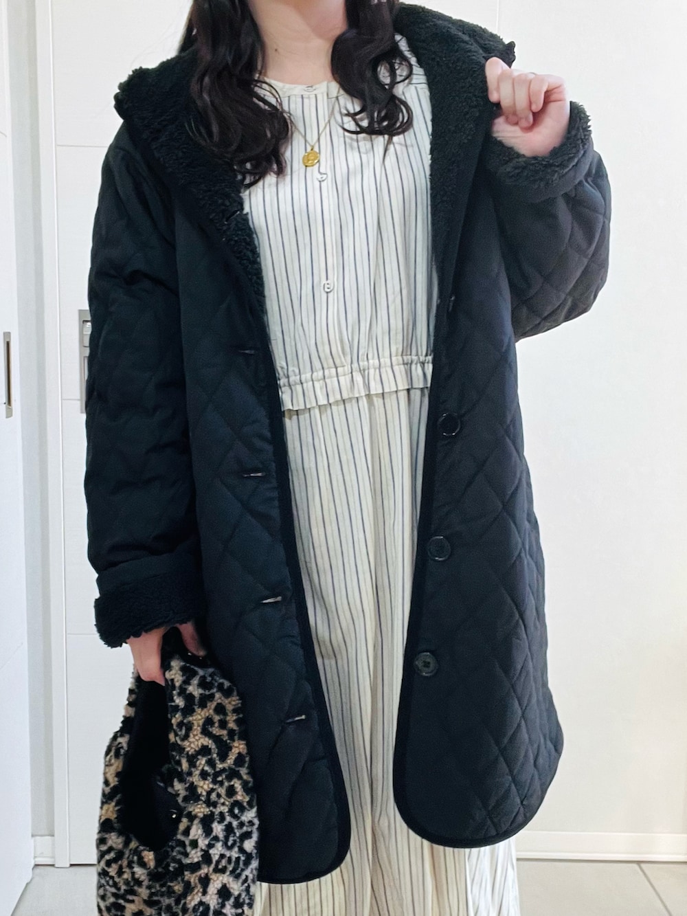 ブラック系のナイロンジャケット、ブルー系のワンピース、ベージュ系のスリッポンを着用したレディースの冬コーディネートの3枚目の写真